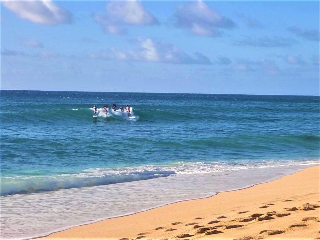 Surfers catching a wave at Banzai Pipeline Oahu